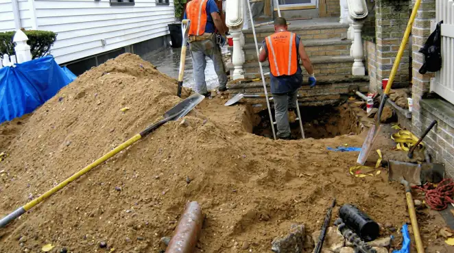 Contractors performing foundation protection and exterior drainage excavation near residential home steps in Pasadena, CA